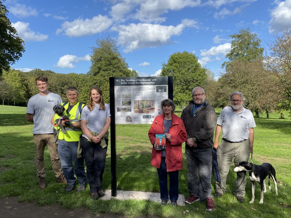Opening-walk participants beside a Cannock Park heritage interpretation panel