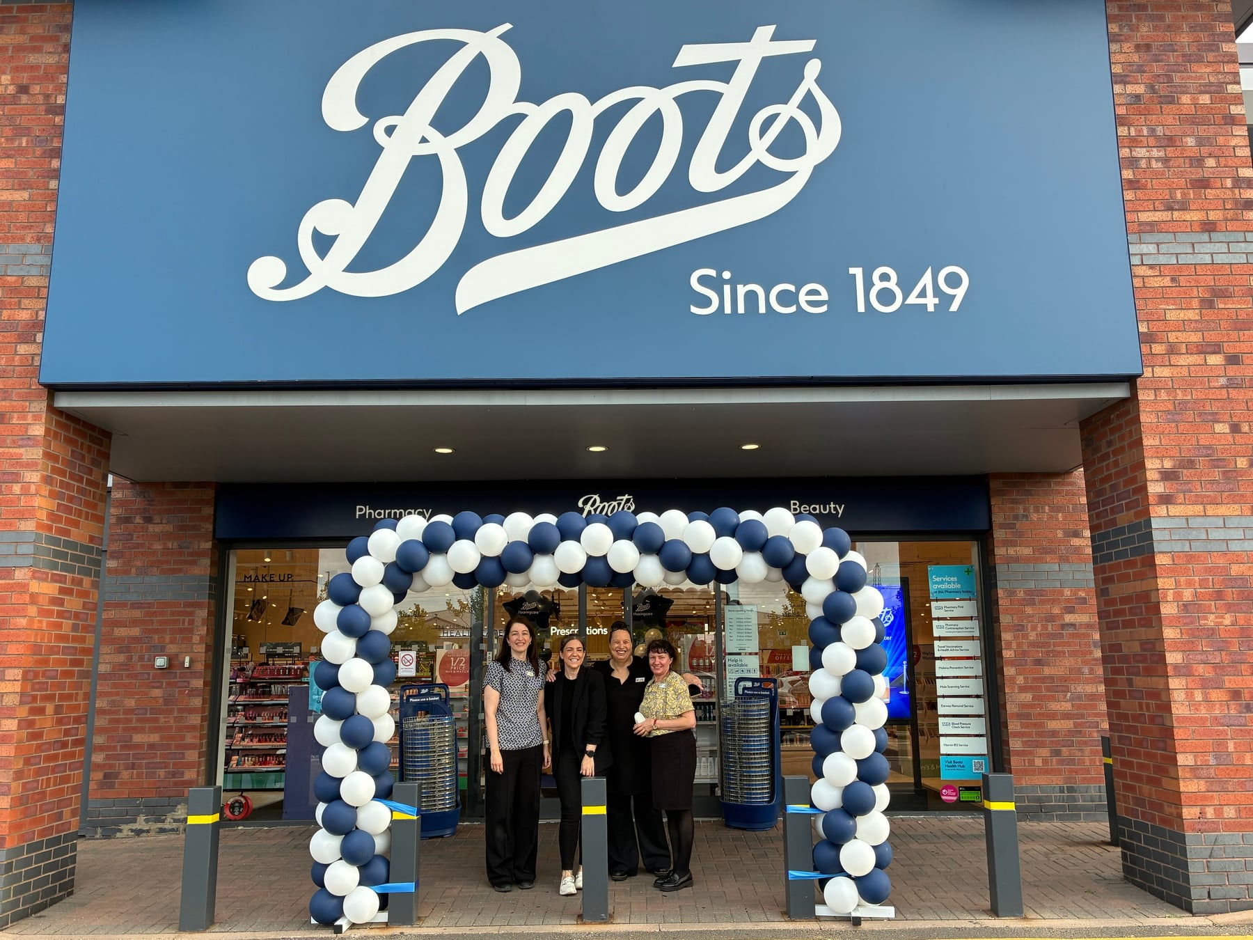 Boots staff beside a balloon arch at the Cannock Orbital store entrance